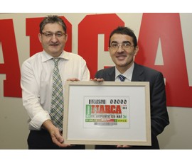 El vicepresidente primero de la ONCE, Andrés Ramos; y el director de Marca, Óscar Campillo muestran una imagen del cupón
