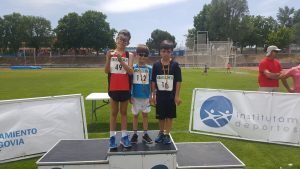 Tres jóvenes atletas afiliados con sus medallas en el podium